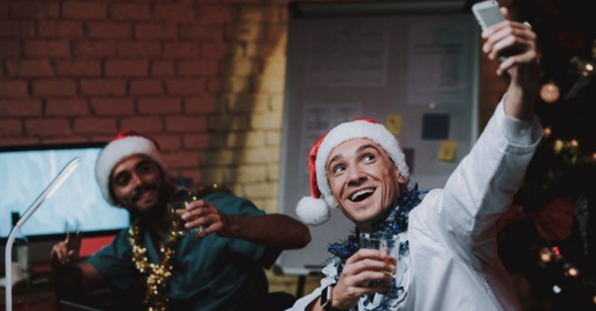 employees drinking and taking photos at holiday party