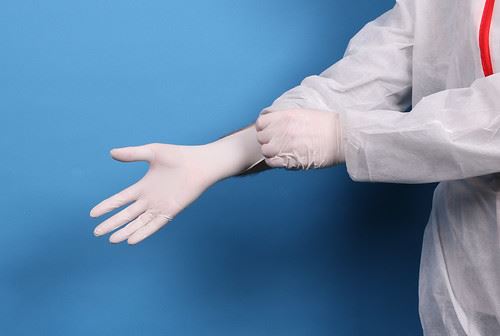 doctor putting on surgical gloves